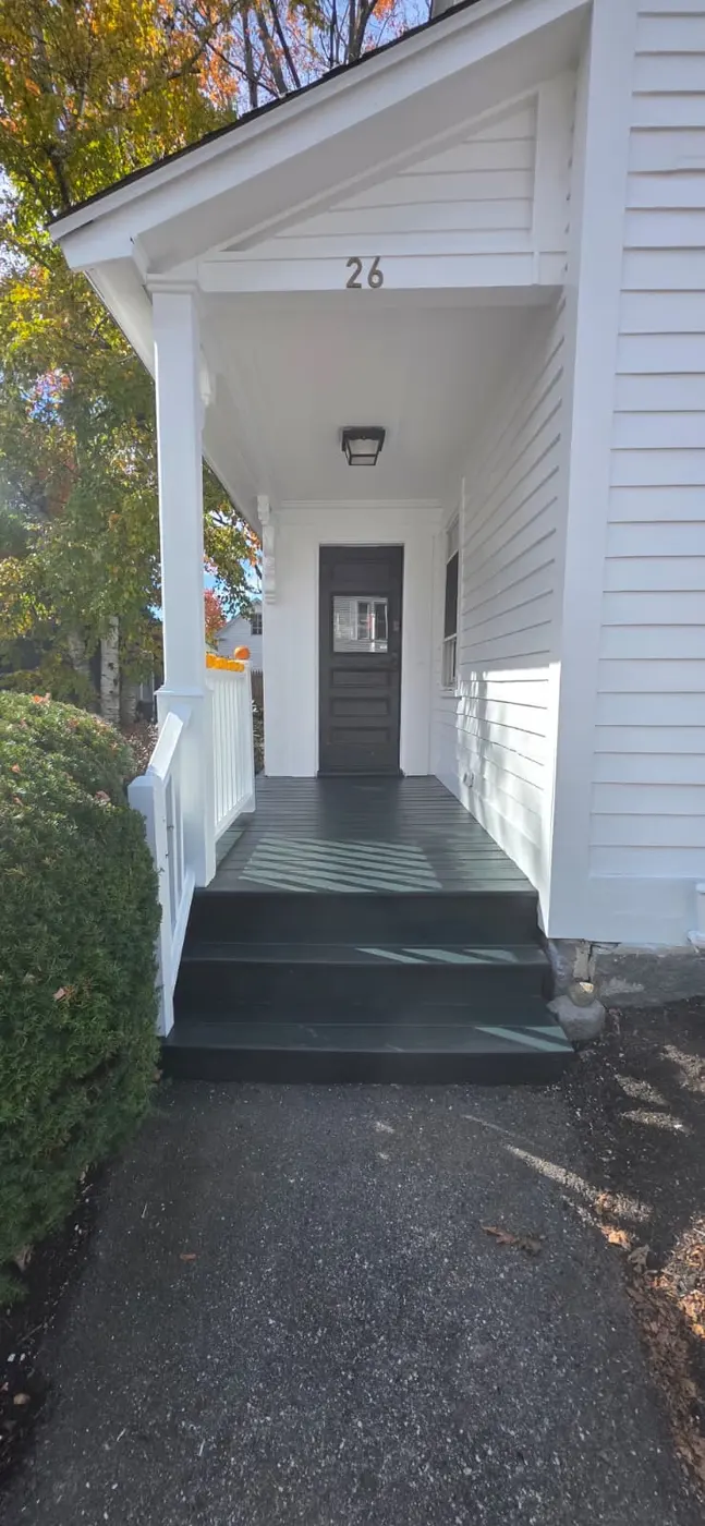 Freshly painted white entry with dark gray steps